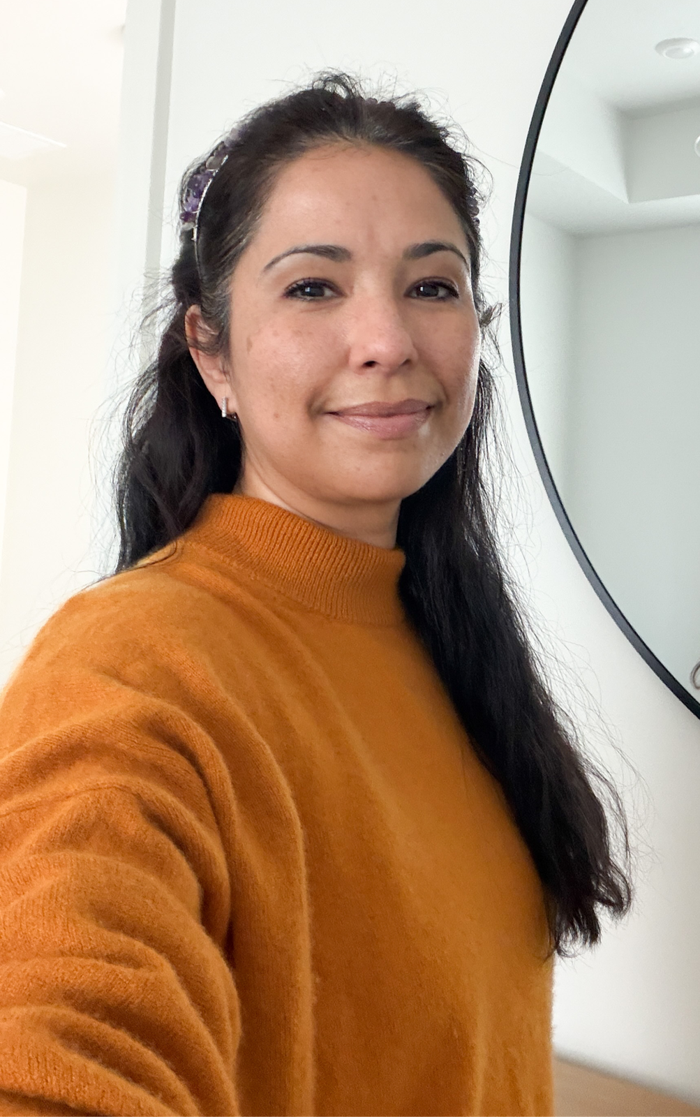 Danielle Klingenmeier in a burnt-orange sweater, an amethyst clip in her hair