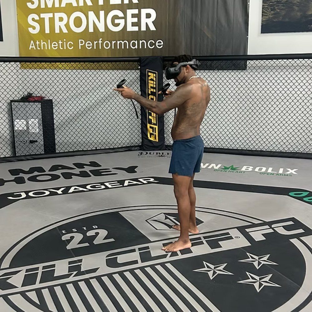 An athlete training in a virtual reality headset inside a gym's practice cage