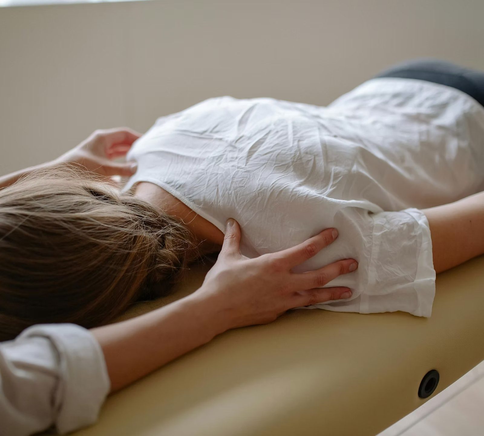 A practitioner’s hands resting on a client’s back during a Reiki session